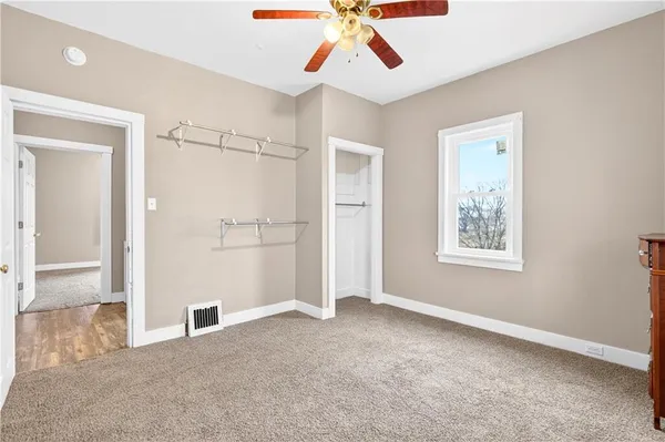 an empty room with closet and windows
