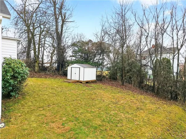 a blue sign board with tall trees