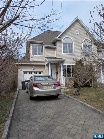 a view of a white house with a large space in front of it