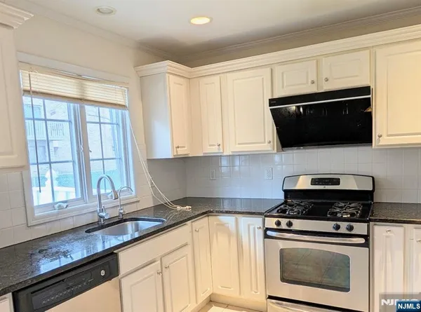 a kitchen with stainless steel appliances a stove microwave and refrigerator