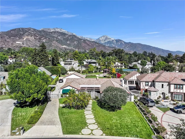 a view of a house with a yard and large trees