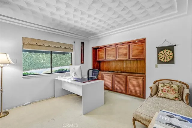 a bedroom with a bed painting and a large window