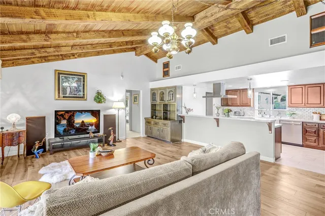 a kitchen with stainless steel appliances a sink a stove a refrigerator cabinets and a dining table