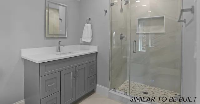 a bathroom with a sink vanity granite shower and a mirror