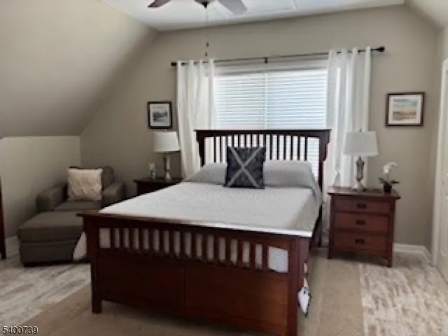 a bedroom with a bed window and a night stand