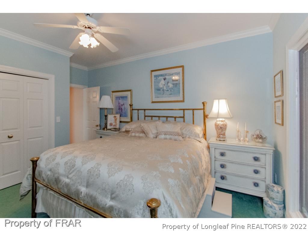 127 Harrell Road West End, NC 27376 - Photo 17 of 27 a bedroom with a bed a lamp on dresser and a chandelier