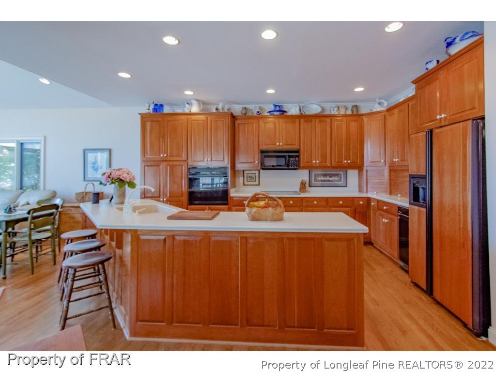 127 Harrell Road West End, NC 27376 - Photo 3 of 27 a kitchen with stainless steel appliances a dining table chairs and a refrigerator