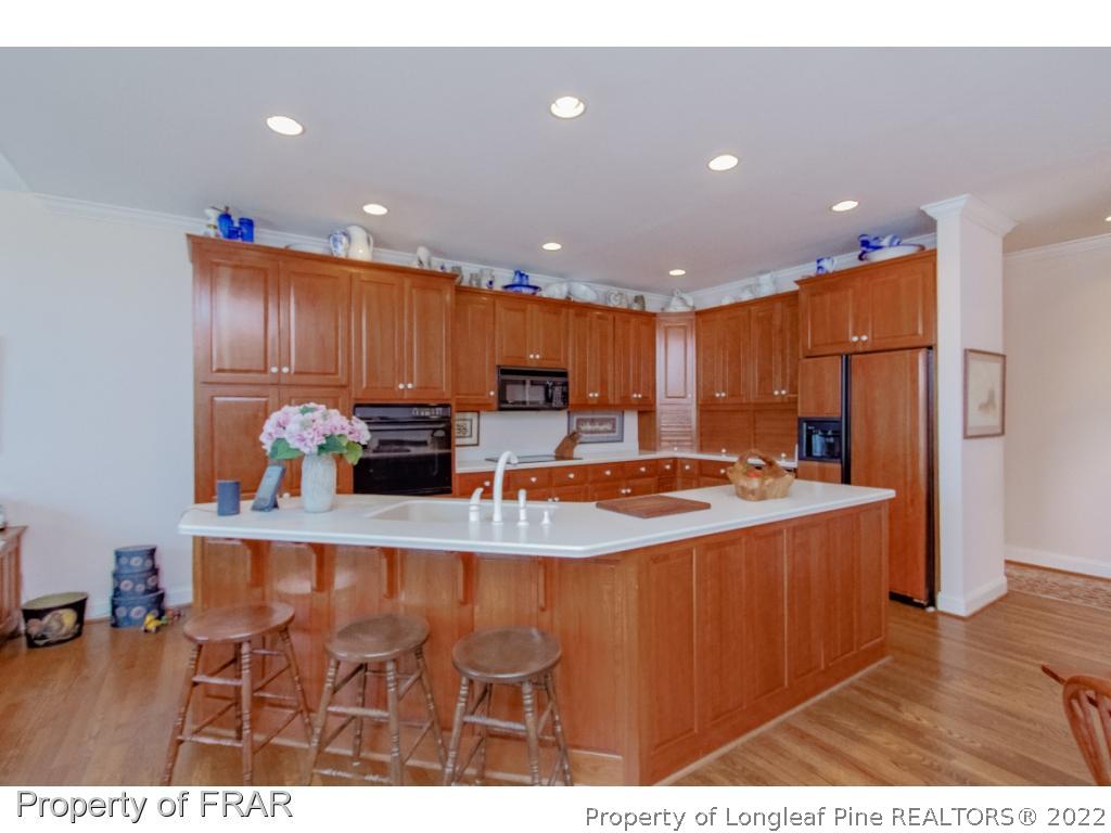 127 Harrell Road West End, NC 27376 - Photo 4 of 27 a kitchen with stainless steel appliances granite countertop a refrigerator a sink dishwasher and a dining table with wooden floor