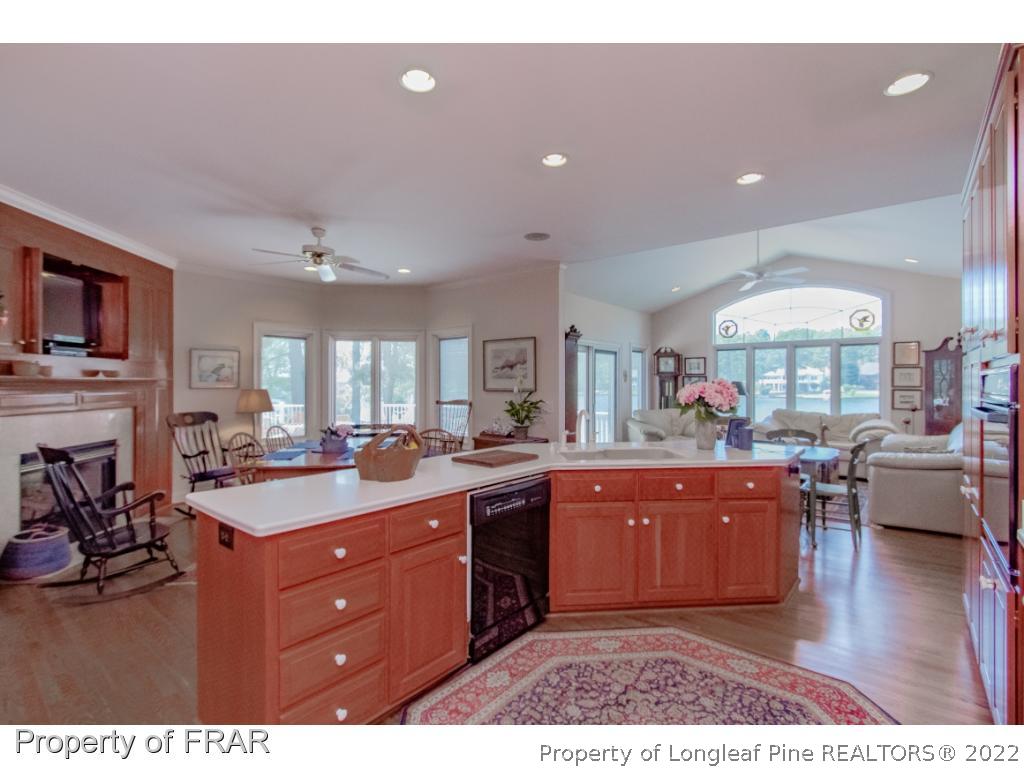 127 Harrell Road West End, NC 27376 - Photo 5 of 27 a kitchen with stainless steel appliances kitchen island granite countertop a sink dishwasher stove and wooden cabinets with wooden floor