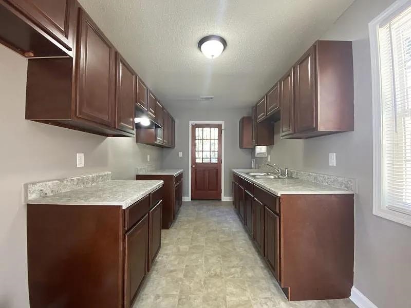 a kitchen with granite countertop stainless steel appliances and wooden cabinets