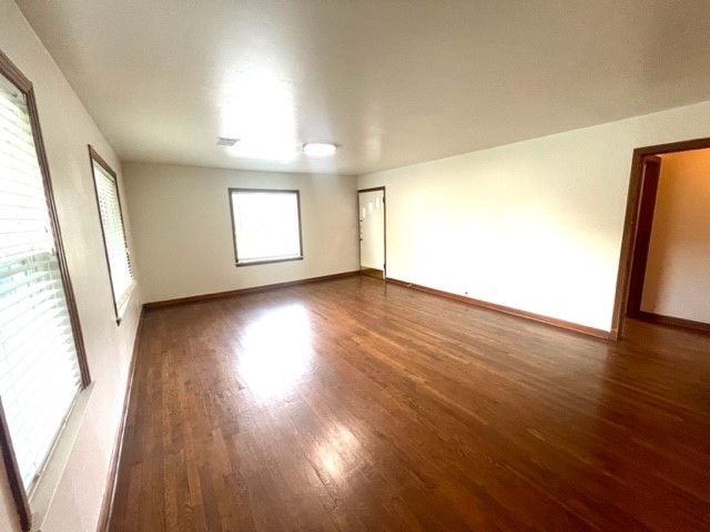 1109 Davis Street Taylor, TX 76574 - Photo 4 of 12 an empty room with wooden floor and windows