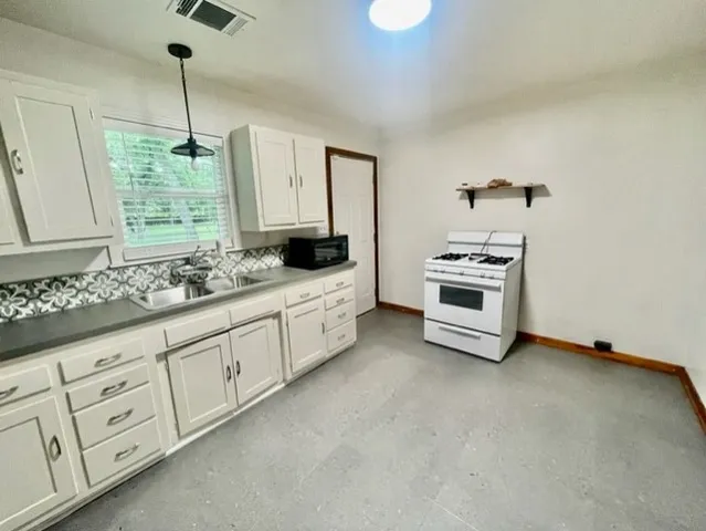 a kitchen with granite countertop white cabinets and white appliances