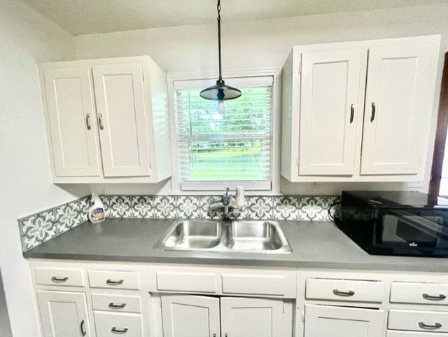 1109 Davis Street Taylor, TX 76574 - Photo 6 of 12 a kitchen with granite countertop white cabinets and window