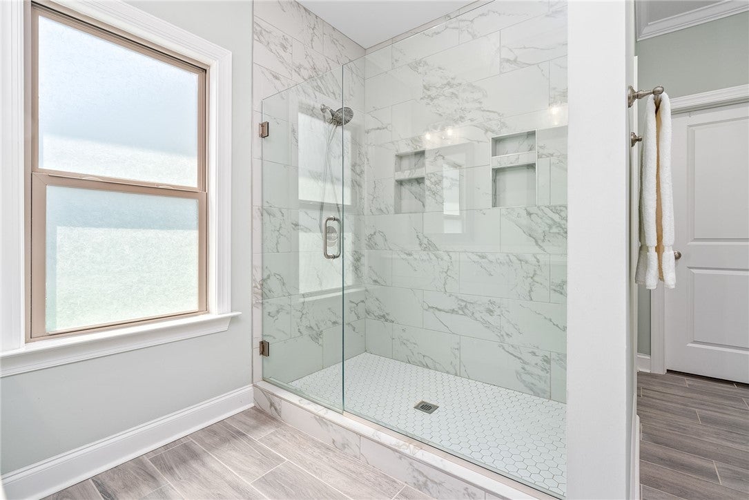 3053 Mimms Trl Road Auburn, AL 36832 - Photo 15 of 45 The primary bath features an elongated vanity with two sinks, a frameless floor-to-ceiling tile shower, a full-size window, a water closet, & a tremendous closet.