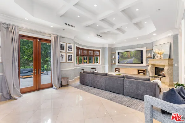 a large living room with stainless steel appliances kitchen island granite countertop a large window and a couch