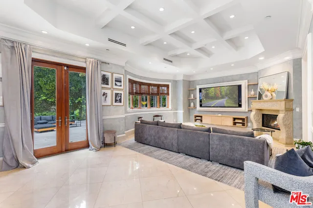 a large living room with stainless steel appliances kitchen island granite countertop a large window and a couch