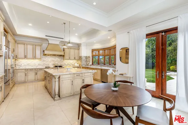 a kitchen with a table chairs microwave and cabinets