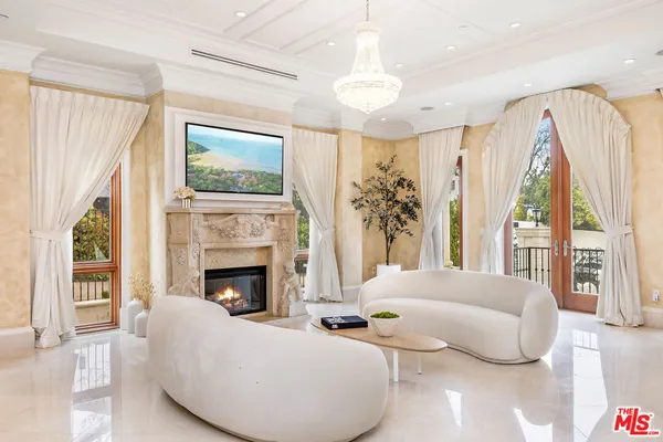 a living room with furniture fireplace and large windows