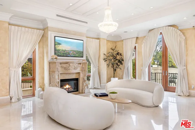 a living room with furniture fireplace and large windows