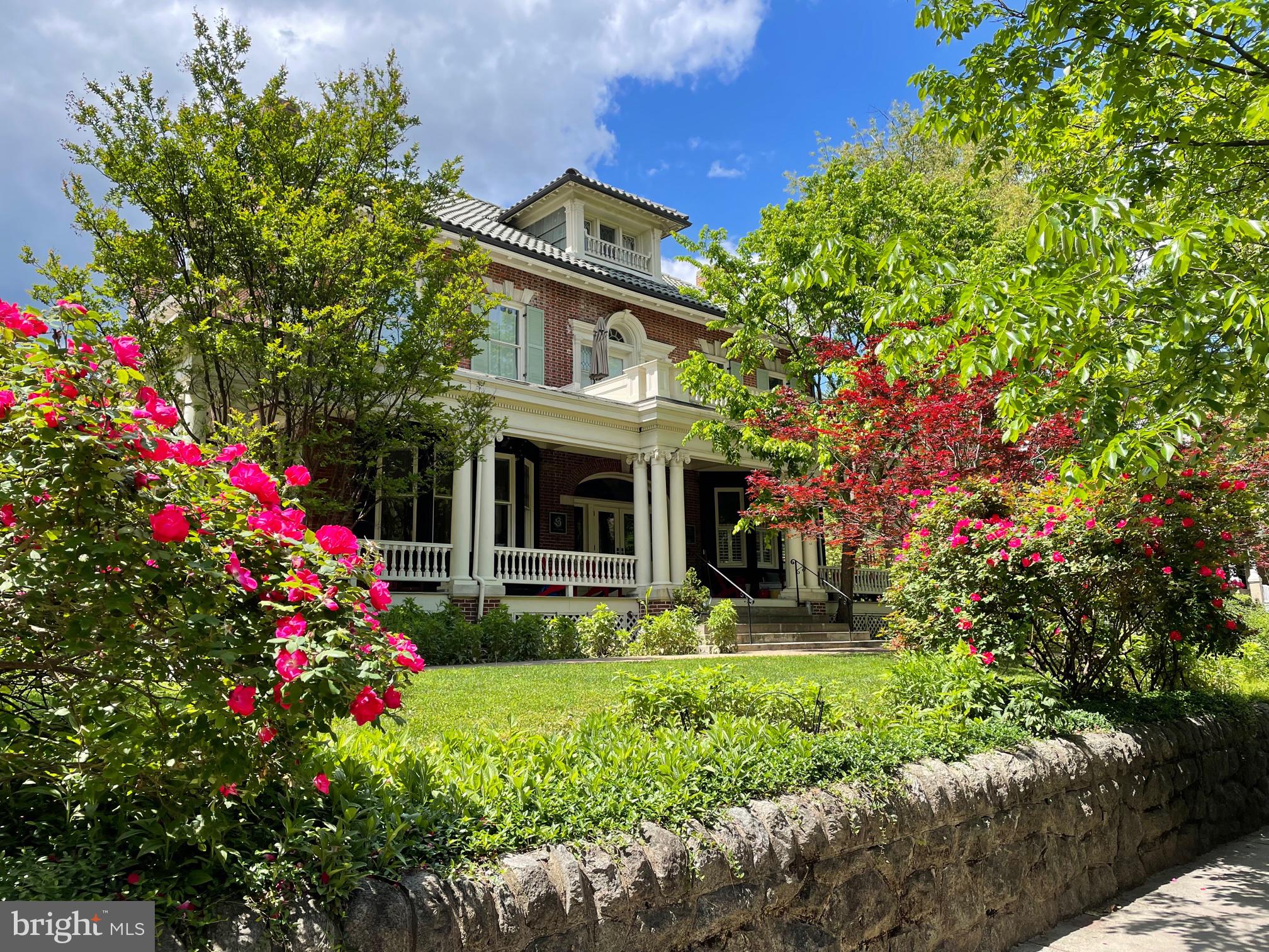 a front view of a house with a yard and fountain