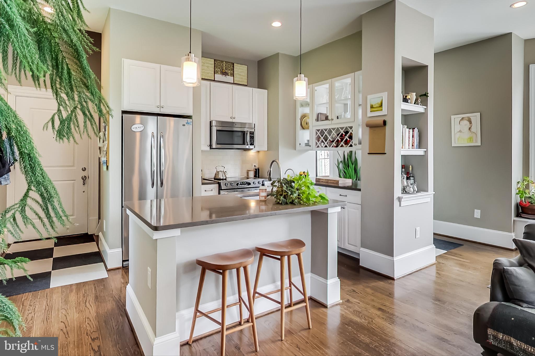 3324 18th Street Northwest, Unit 9 Washington, DC 20010 - Photo 15 of 44 a kitchen with stainless steel appliances a refrigerator a stove a sink and white cabinets with wooden floor