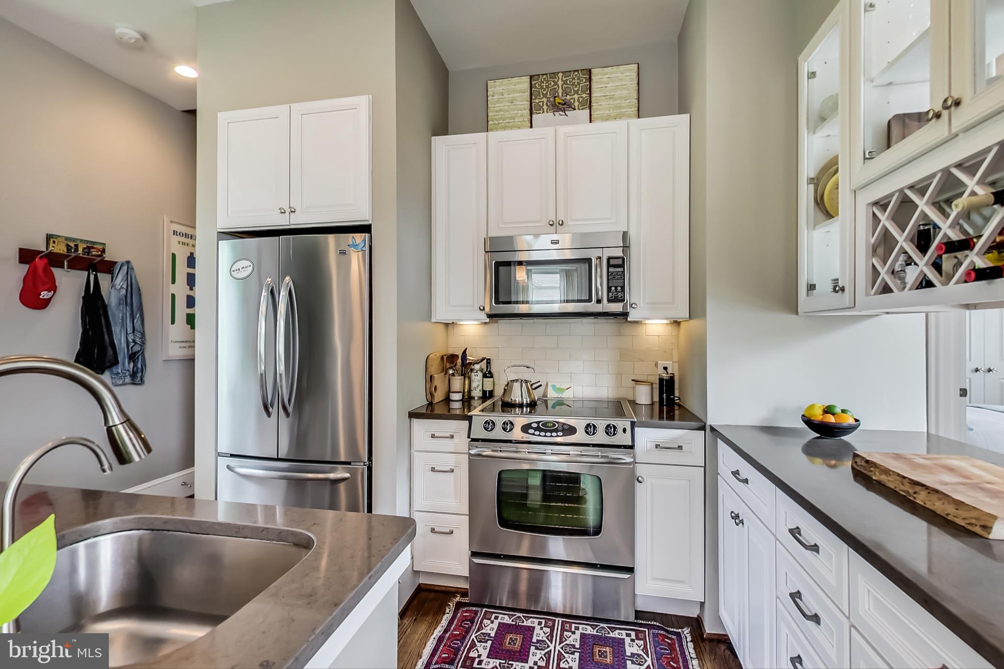 3324 18th Street Northwest, Unit 9 Washington, DC 20010 - Photo 16 of 44 a kitchen with stainless steel appliances a stove a sink a microwave and cabinets