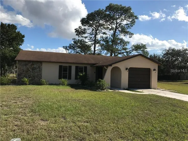 a front view of house with yard and trees