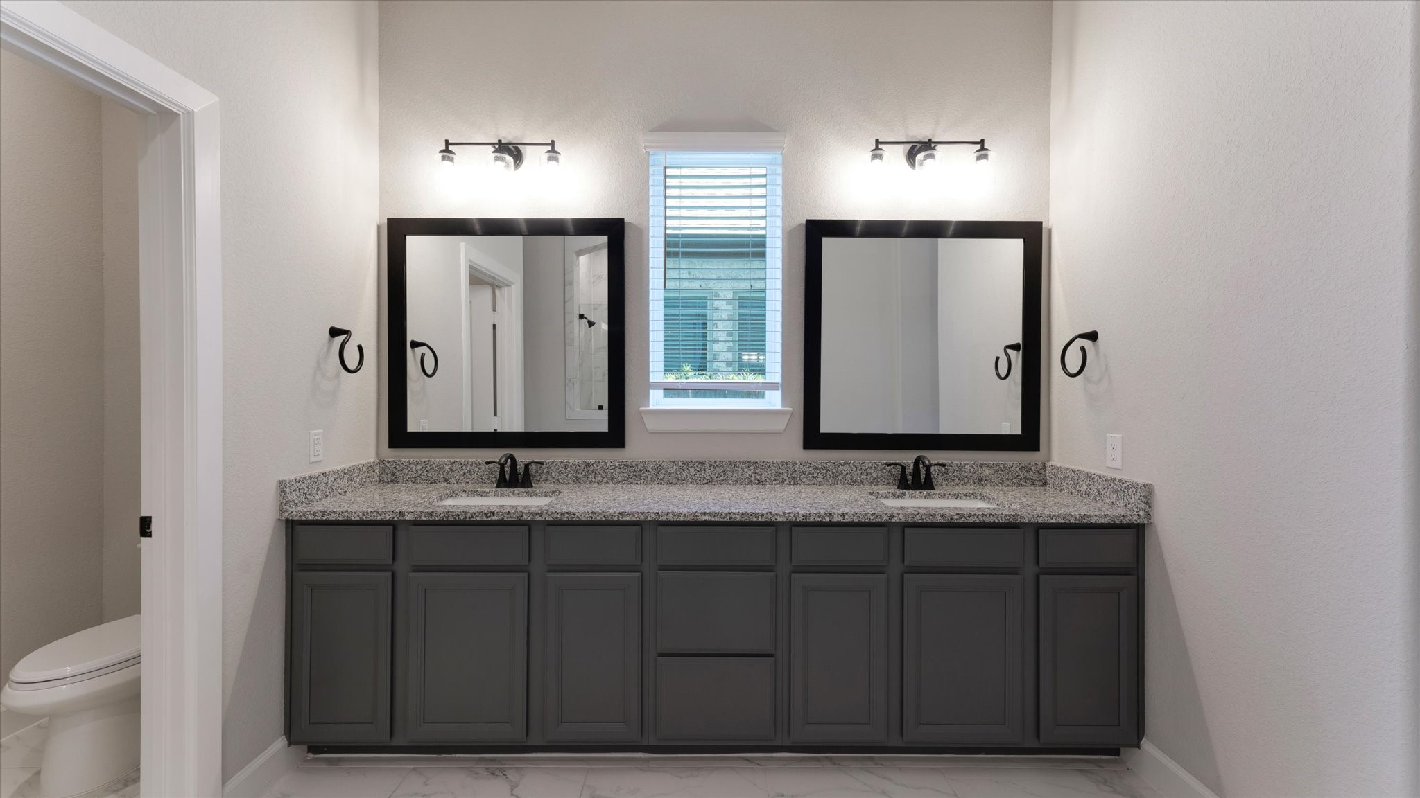 15607 Rising Wren Court Conroe, TX 77302 - Photo 21 of 40 a bathroom with a granite countertop sink and a mirror