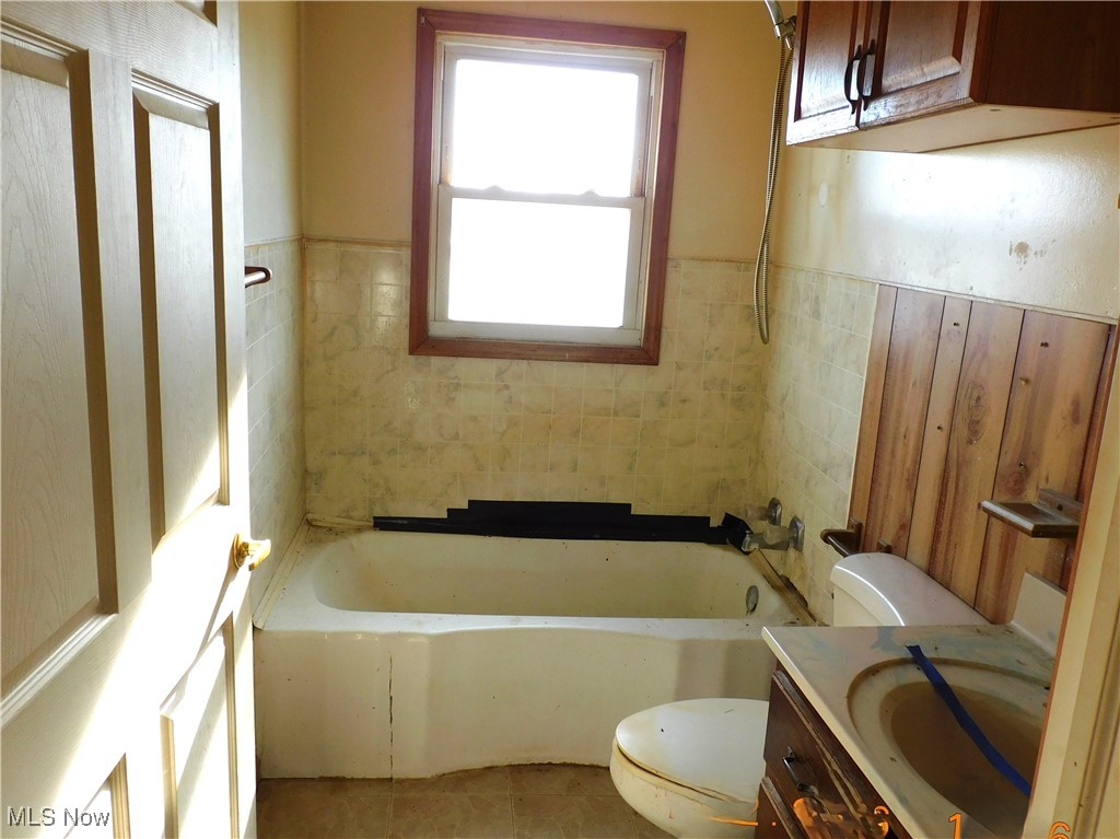 352 South Ridge Road East Conneaut, OH 44030 - Photo 11 of 21 Bathroom with vanity, wainscoting, tile patterned floors, and shower / tub combination
