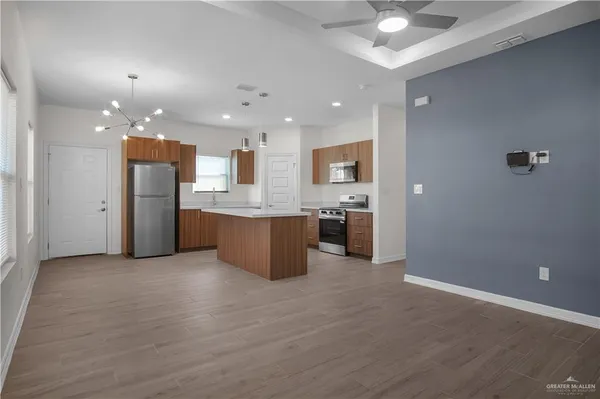 a open kitchen with a refrigerator a kitchen island a stove and a sink