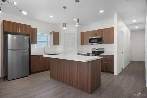 a kitchen with stainless steel appliances a refrigerator and a stove top oven