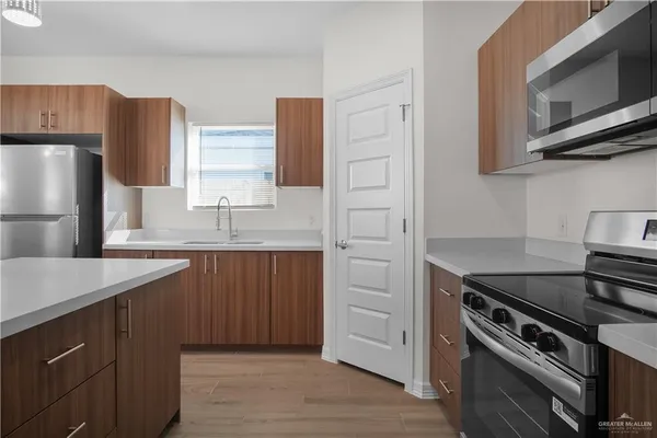 a kitchen with stainless steel appliances a stove microwave and refrigerator