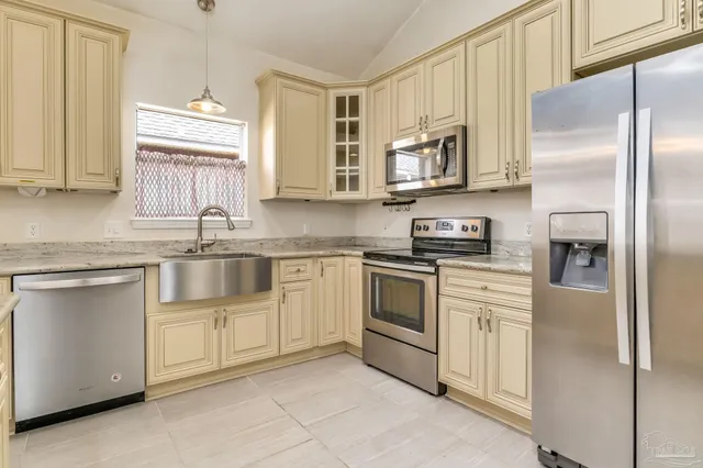 a kitchen with stainless steel appliances granite countertop a refrigerator sink and stove