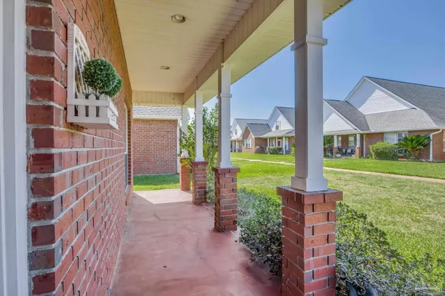 a view of a brick house with a yard and plants