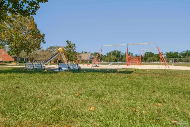 a view of a tennis ground with large trees