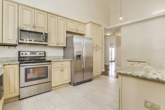 a kitchen with stainless steel appliances granite countertop a refrigerator a stove and a sink