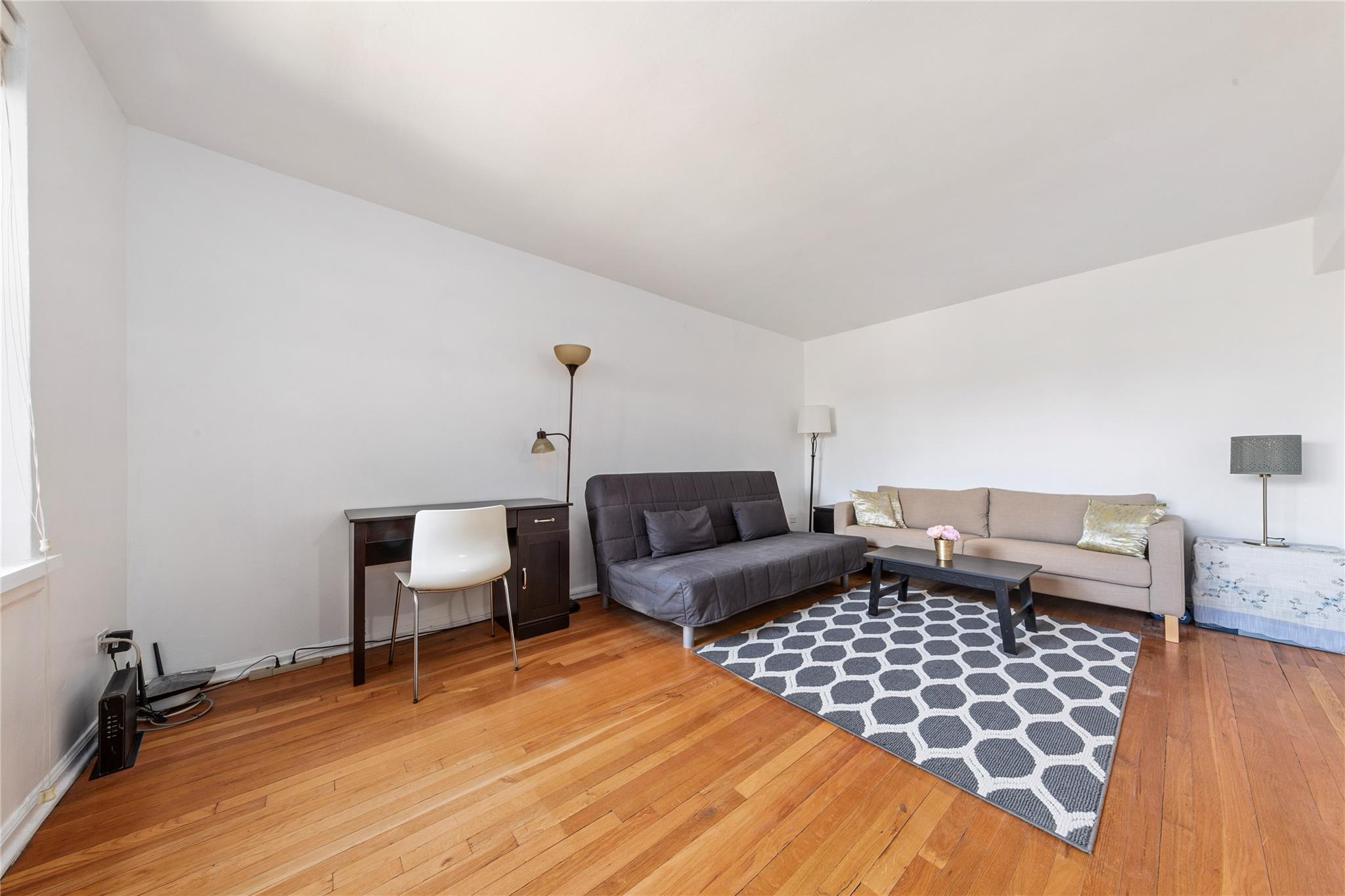 73-62 Bell Boulevard, Unit 4K Queens, NY 11364 - Photo 2 of 16 Living room featuring baseboards and wood-type flooring