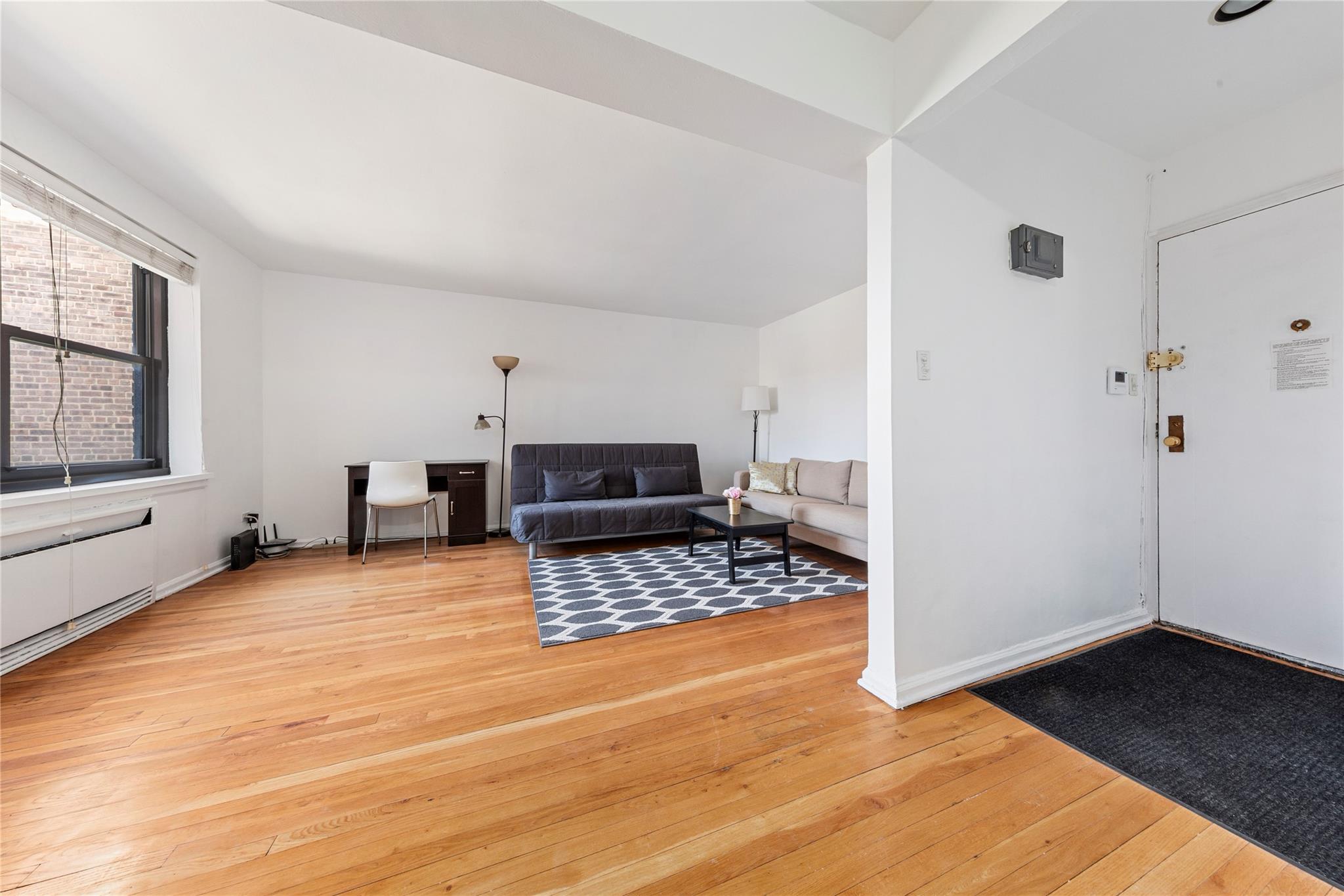 73-62 Bell Boulevard, Unit 4K Queens, NY 11364 - Photo 4 of 16 Living room with baseboards and light wood-style flooring