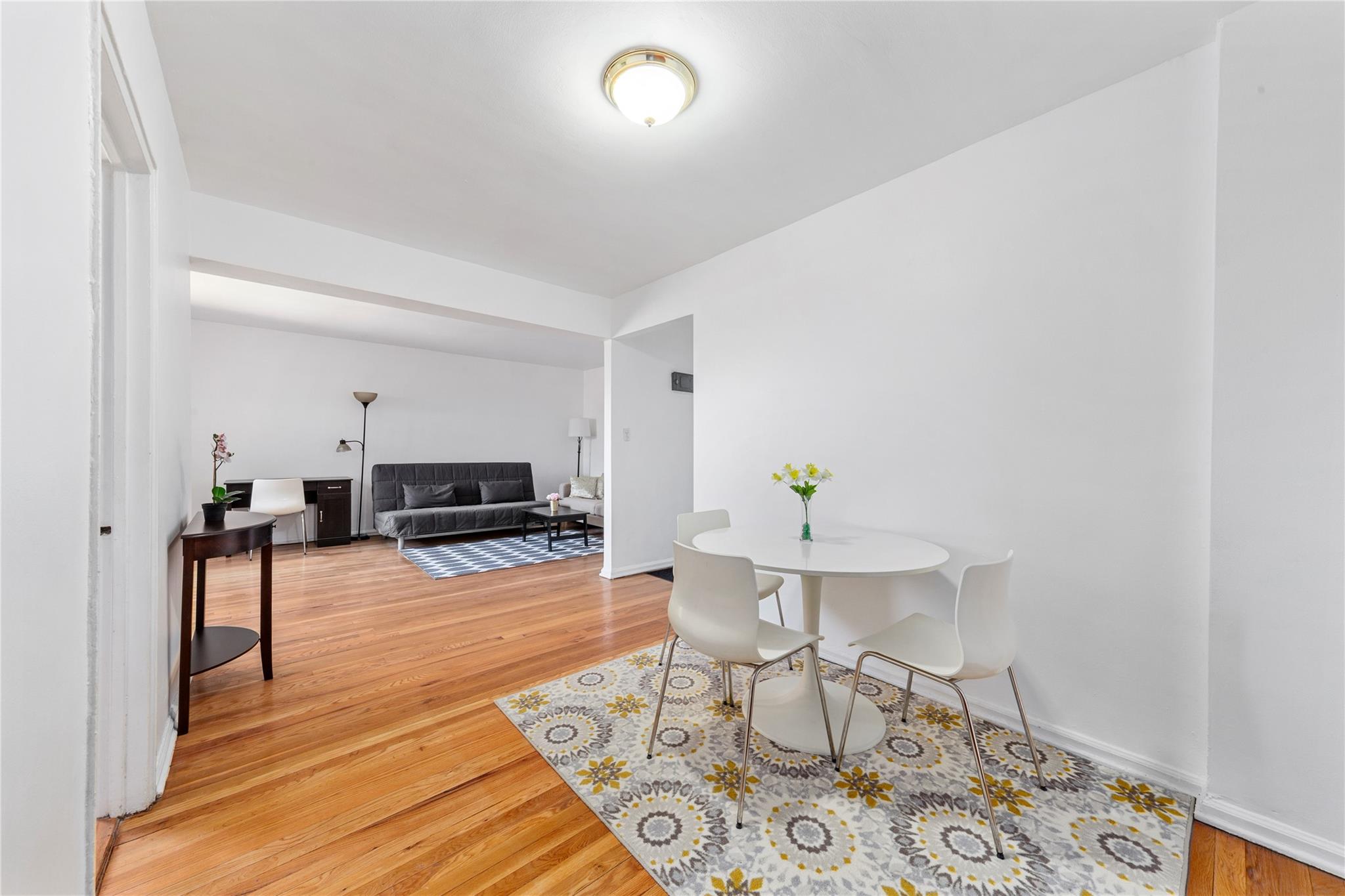 73-62 Bell Boulevard, Unit 4K Queens, NY 11364 - Photo 9 of 16 Dining space with light wood-style flooring and baseboards