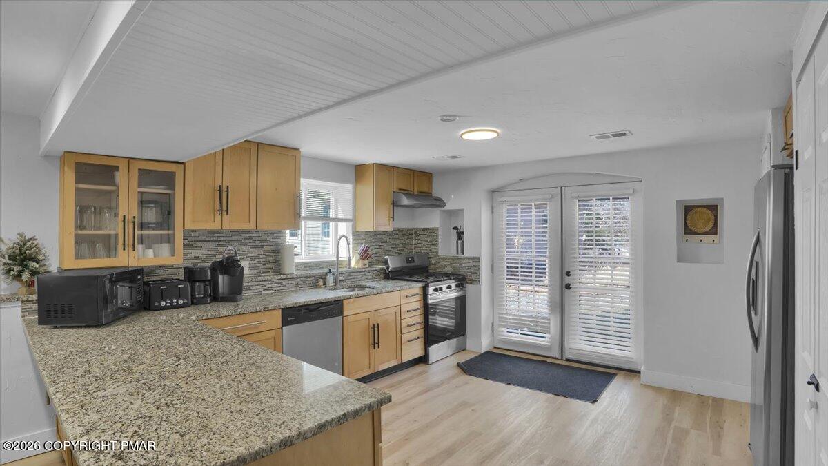 65 Highridge Road Albrightsville, PA 18210 - Photo 5 of 60 a kitchen with stainless steel appliances granite countertop a stove top oven a sink dishwasher a dining table and chairs with wooden floor