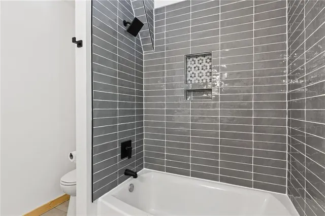 a view of a big room with wooden floor and windows