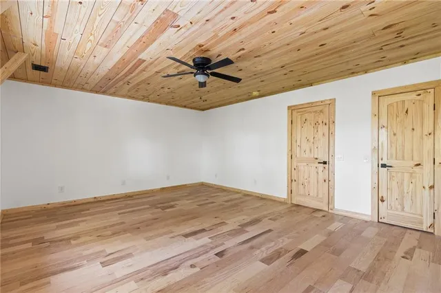 a view of a hallway with wooden floor and windows