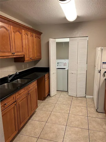 a kitchen with a stove a refrigerator and cabinets
