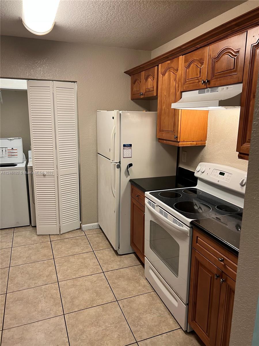 3837 Northwest 76th Way Davie, FL 33024 - Photo 22 of 34 a kitchen with a stove a refrigerator and cabinets