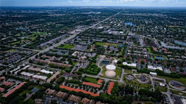 an aerial view of residential houses with outdoor space and trees