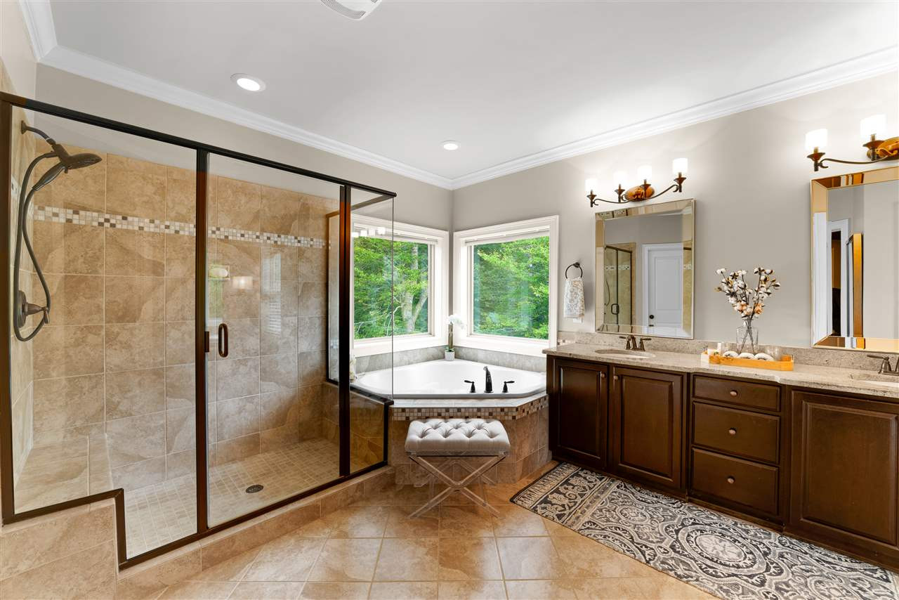 9120 Concord Hill Court Raleigh, NC 27613 - Photo 26 of 30 Master bath features a corner soaking tub, a separate glass enclosed shower with a built in seat, and his and her walk in closets. Master Bath/Spa