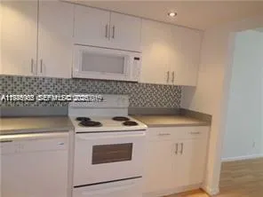 a kitchen with granite countertop cabinets stove top oven and sink