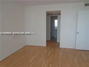 a view of a room with wooden floor and cabinet
