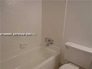 a bath tub sitting next to a white toilet