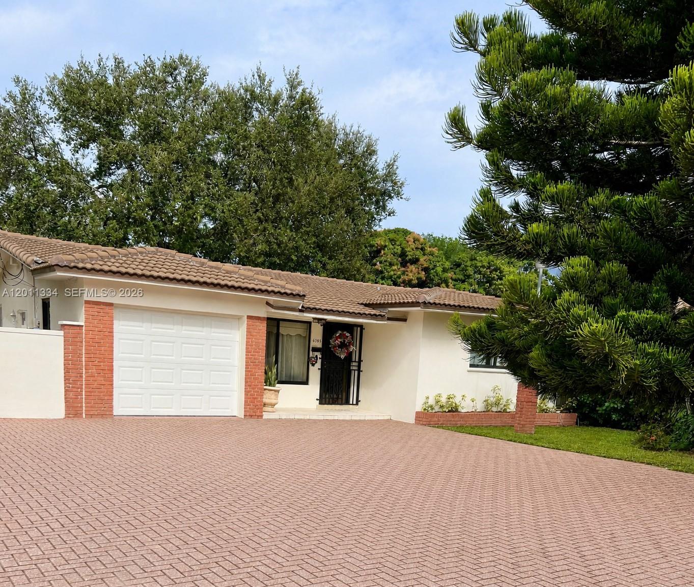 6385 Southwest 25th Street Miami, FL 33155 - Photo 2 of 28 a front view of a house with a yard and garage